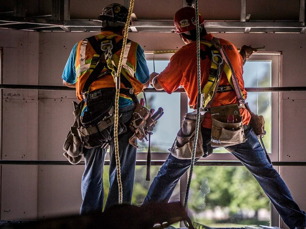 two workers on a lift working on speciality ceilings